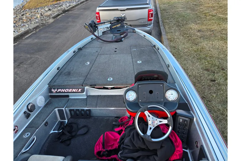 Slide: The Image of 2015 Phoenix 819 Pro boat interior with steering wheel and dashboard, parked near a truck. - 11