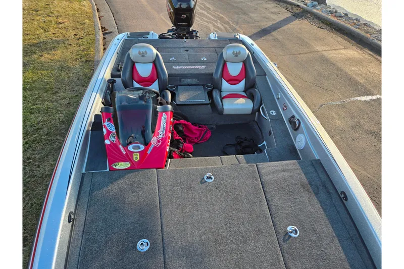 Slide: The Image of 2015 Phoenix 819 Pro boat interior with red and gray seating, parked on a road. - 18