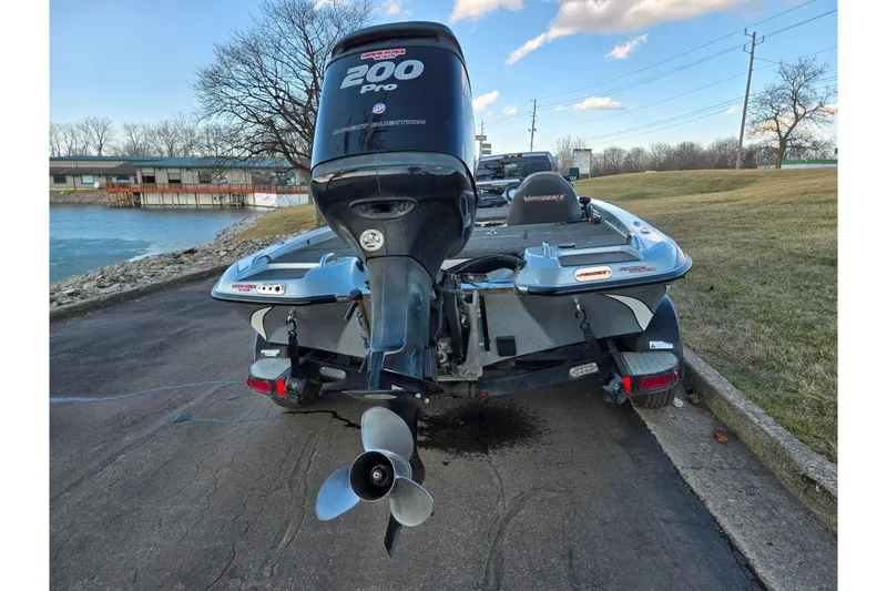 Slide: The Image of 2015 Phoenix 819 Pro boat with 200 Pro outboard motor, parked near a lake. - 2