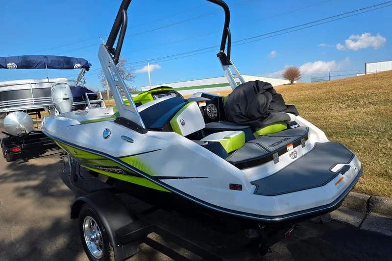 Slide: The Image of 2015 Scarab 165 H.O. Impulse boat on trailer, vibrant green accents, sunny day. - 3