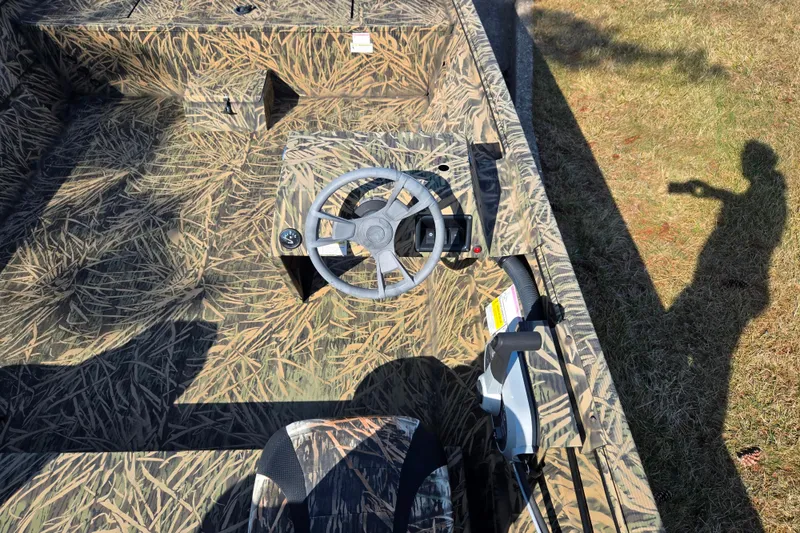Slide: The Image of 2020 Lowe Roughneck 2070SC boat interior with camouflage design and steering wheel. - 12