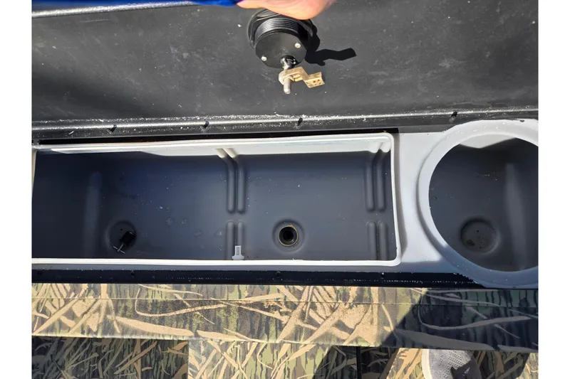 Slide: The Image of 2020 Lowe Roughneck 2070SC boat storage compartment with cup holder and camouflage flooring. - 16
