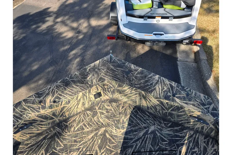 Slide: The Image of 2020 Lowe Roughneck 2070SC boat with camouflage pattern, parked on a street. - 17