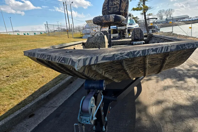 Slide: The Image of 2020 Lowe Roughneck 2070SC boat on trailer, camo design, parked outdoors. - 7