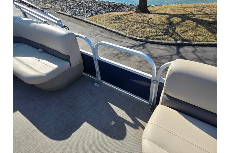 Slide: The Image of 2021 Sun Tracker Party Barge 18 DLX interior with beige seating and lake view. - 12
