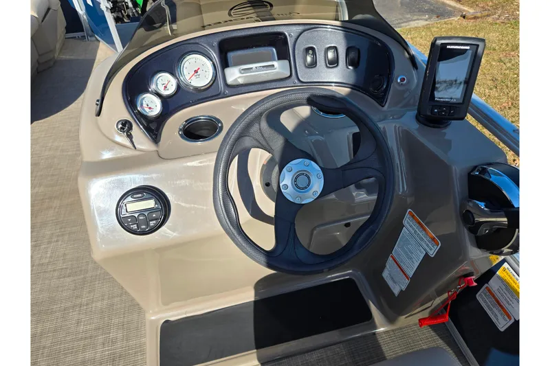 Slide: The Image of 2021 Sun Tracker Party Barge 18 DLX dashboard with steering wheel and gauges. - 18