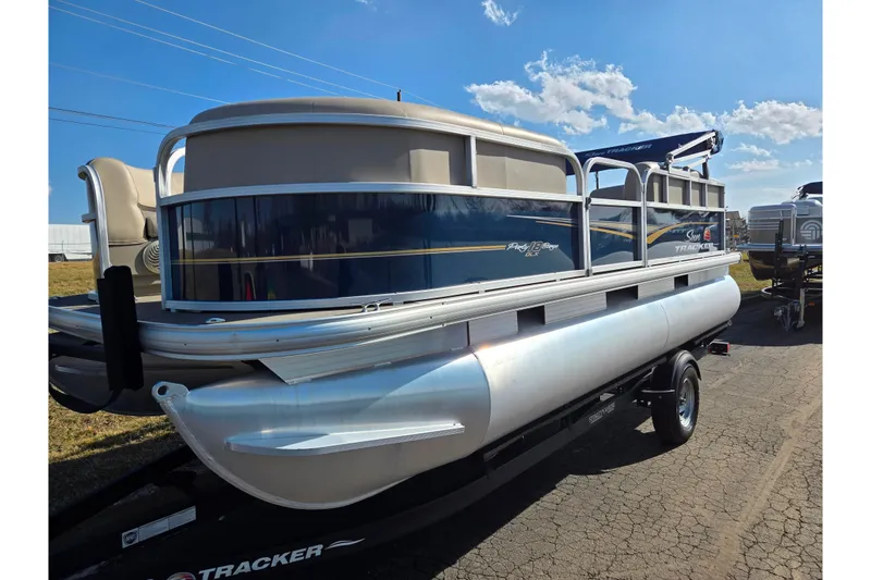Slide: The Image of 2021 Sun Tracker Party Barge 18 DLX pontoon boat on trailer under blue sky. - 5