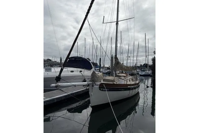 Slide: The Image of Bristol Channel Cutter 28 sailboat, 1997 model, docked in a marina under cloudy skies. - 14