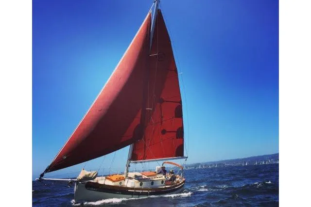 Slide: The Image of Bristol Channel Cutter 28 sailing on open water, 1997 model, with red sails. - 16