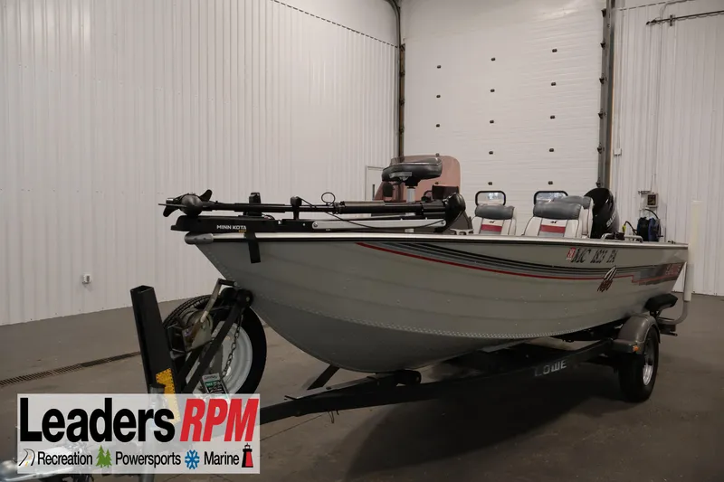 The Image of 1990 Lowe 1620V boat on trailer in indoor showroom setting. - 1