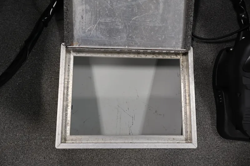 Slide: The Image of Open storage compartment on a 1990 Lowe 1620V boat, showing interior details. - 16