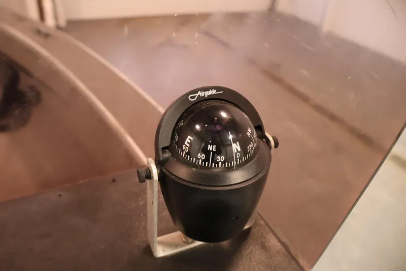 Slide: The Image of Boat compass on a 1990 Lowe 1620V, displaying cardinal directions. - 24