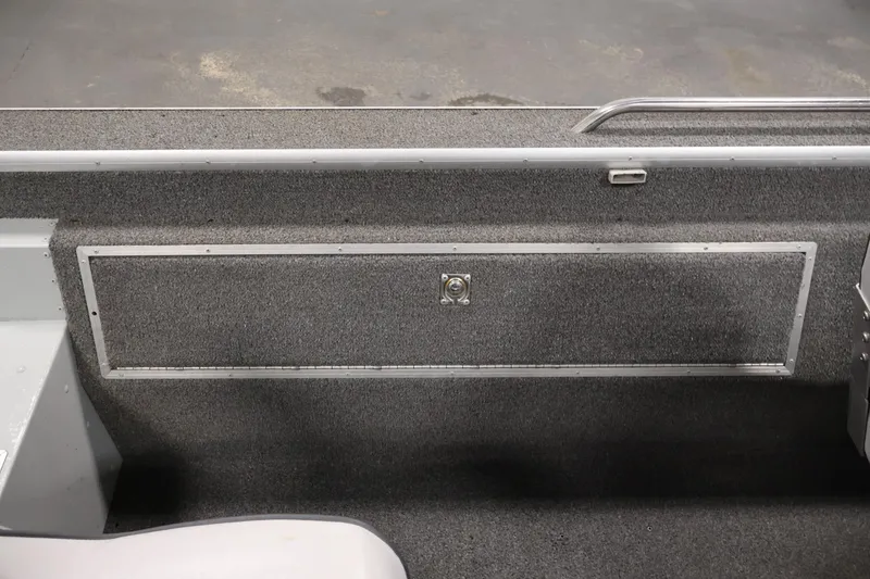 Slide: The Image of 1990 Lowe 1620V boat interior with carpeted storage compartment and metal handle. - 31