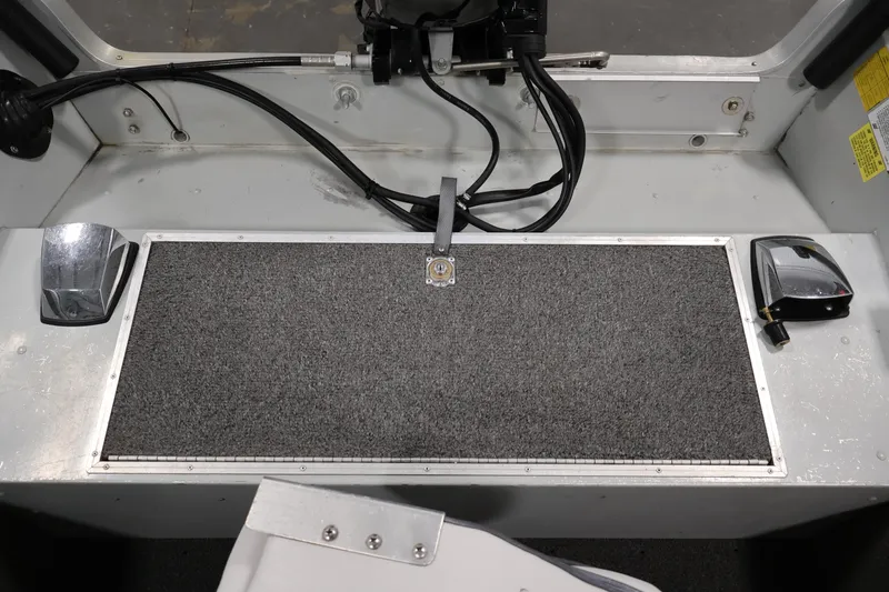 Slide: The Image of Interior of a 1990 Lowe 1620V boat showing control cables and carpeted surface. - 34