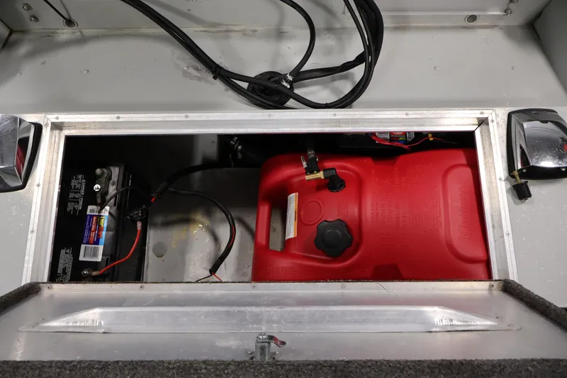 Slide: The Image of Open compartment in 1990 Lowe 1620V boat showing battery and red fuel tank. - 35