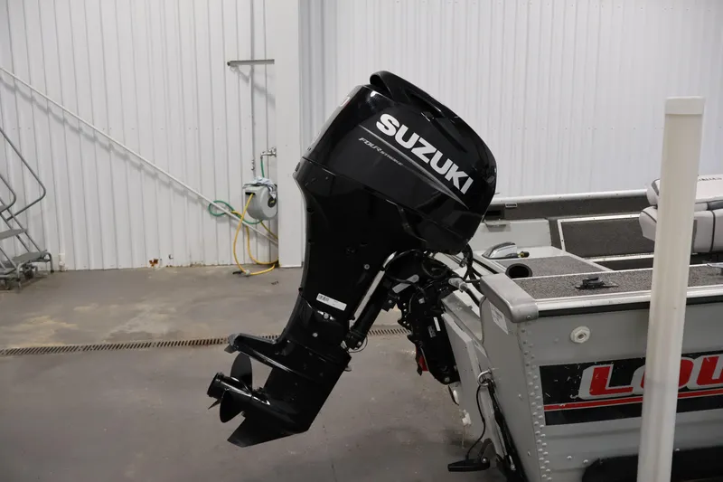 Slide: The Image of 1990 Lowe 1620V boat with Suzuki outboard motor in a garage setting. - 40