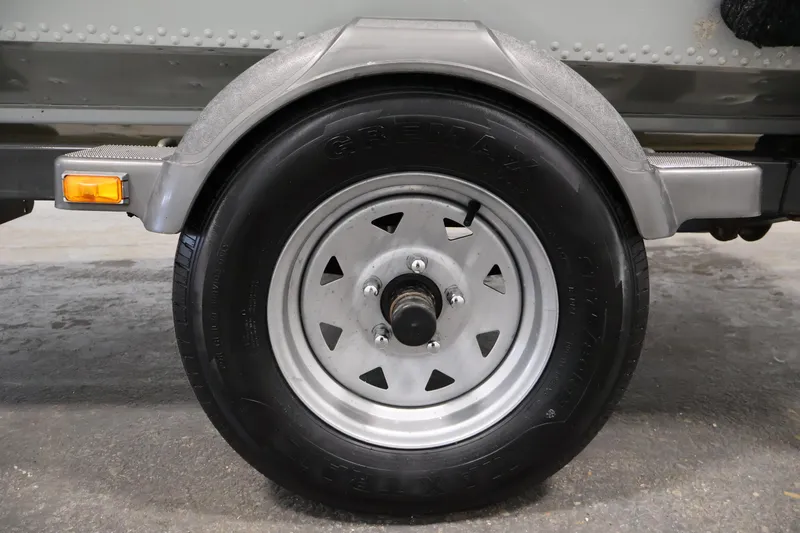 Slide: The Image of Close-up of a 1990 Lowe 1620V trailer wheel with tire and fender. - 46