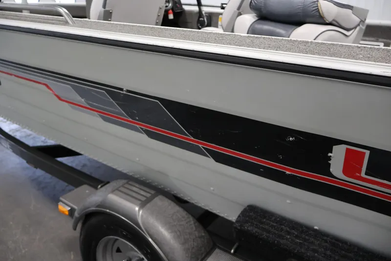 Slide: The Image of 1990 Lowe 1620V boat with gray and red detailing on a trailer. - 47
