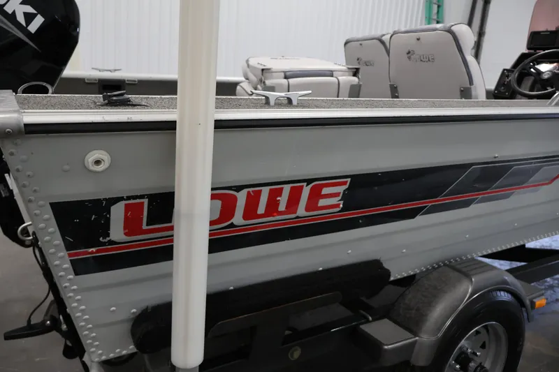Slide: The Image of 1990 Lowe 1620V boat with Suzuki motor, interior seating visible. - 49