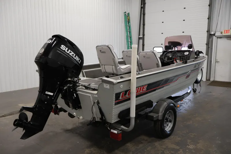 Slide: The Image of 1990 Lowe 1620V boat with Suzuki outboard motor in a garage setting. - 5