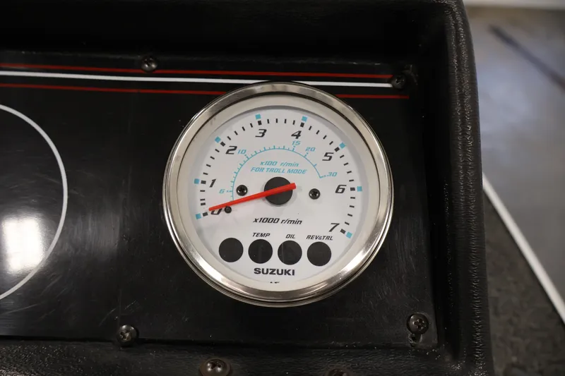 Slide: The Image of Tachometer on 1990 Lowe 1620V boat dashboard, featuring Suzuki branding. - 51