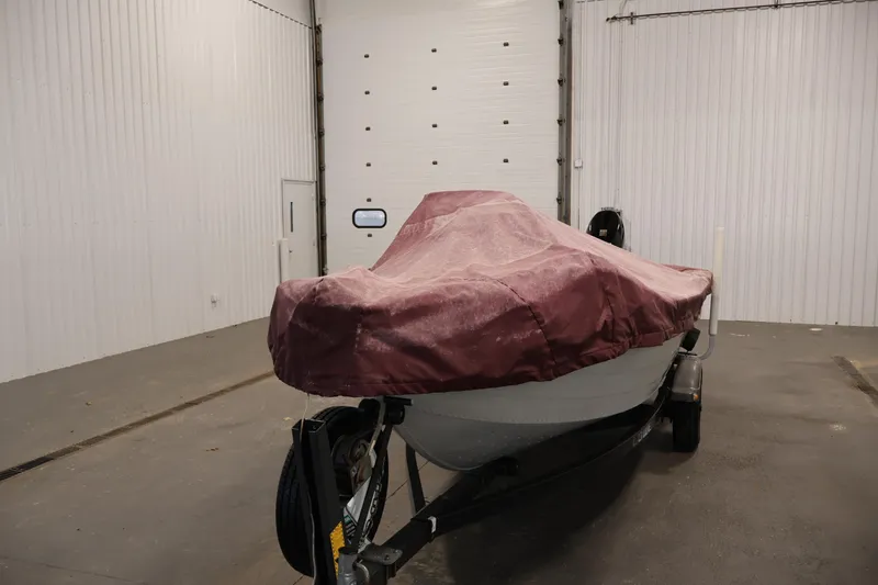 Slide: The Image of Covered 1990 Lowe 1620V boat on trailer in indoor storage facility. - 52