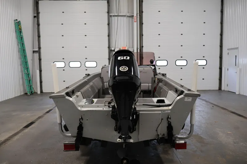 Slide: The Image of 1990 Lowe 1620V boat with 60HP motor in a garage setting. - 6