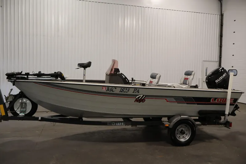 Slide: The Image of 1990 Lowe 1620V fishing boat with Suzuki motor on trailer in indoor setting. - 8