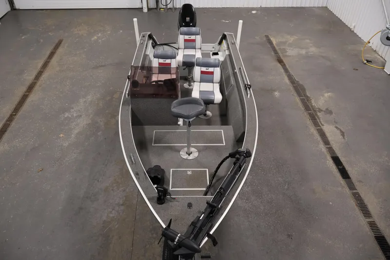 Slide: The Image of 1990 Lowe 1620V boat with seating, steering console, and trolling motor in a garage. - 9