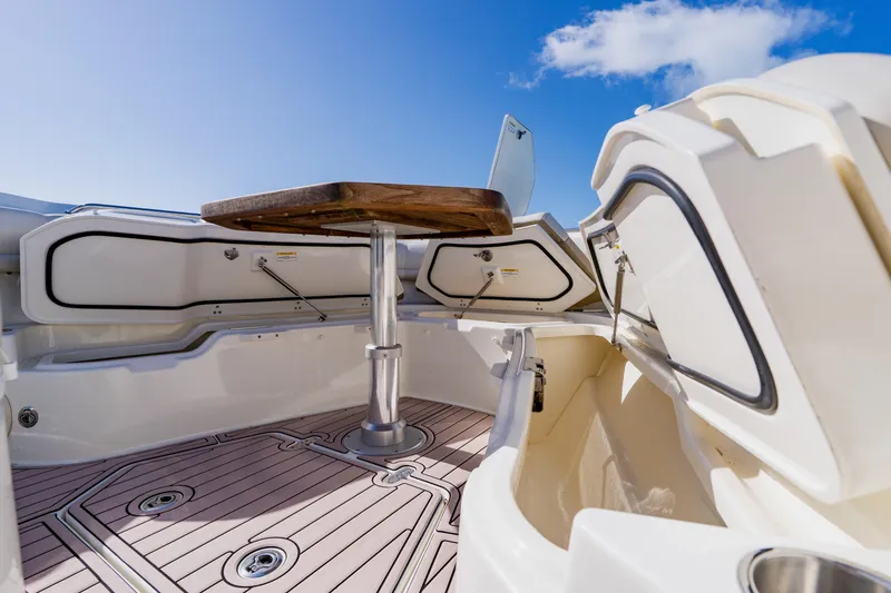 Slide: The Image of 2019 Boston Whaler 380 Outrage interior with table, storage, and clear blue sky. - 12