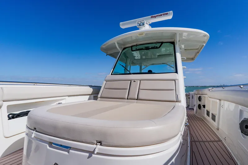 Slide: The Image of 2019 Boston Whaler 380 Outrage boat with spacious deck and seating under clear blue sky. - 14