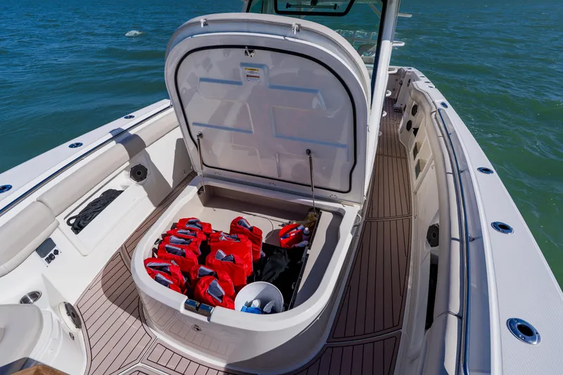 Slide: The Image of 2019 Boston Whaler 380 Outrage boat with open storage compartment and life jackets. - 15