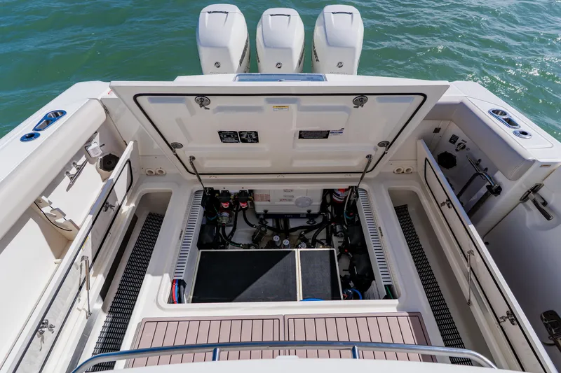 Slide: The Image of 2019 Boston Whaler 380 Outrage engine compartment with open hatch, showcasing mechanical components. - 35