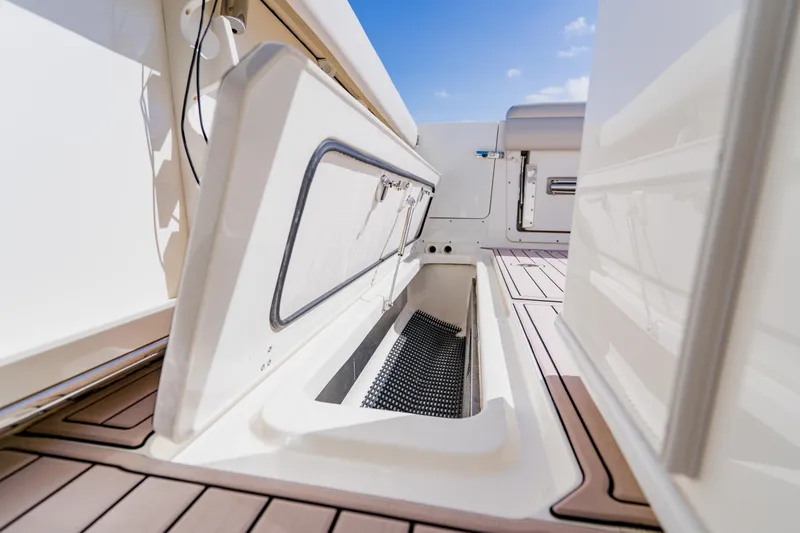 Slide: The Image of 2019 Boston Whaler 380 Outrage storage compartment with open hatch on deck. - 36