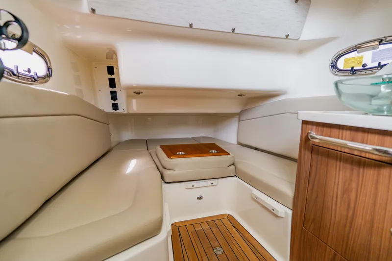 Slide: The Image of 2019 Boston Whaler 380 Outrage cabin interior with beige seating and wooden accents. - 42