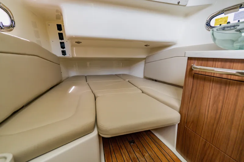 Slide: The Image of 2019 Boston Whaler 380 Outrage cabin interior with beige seating and wood accents. - 43