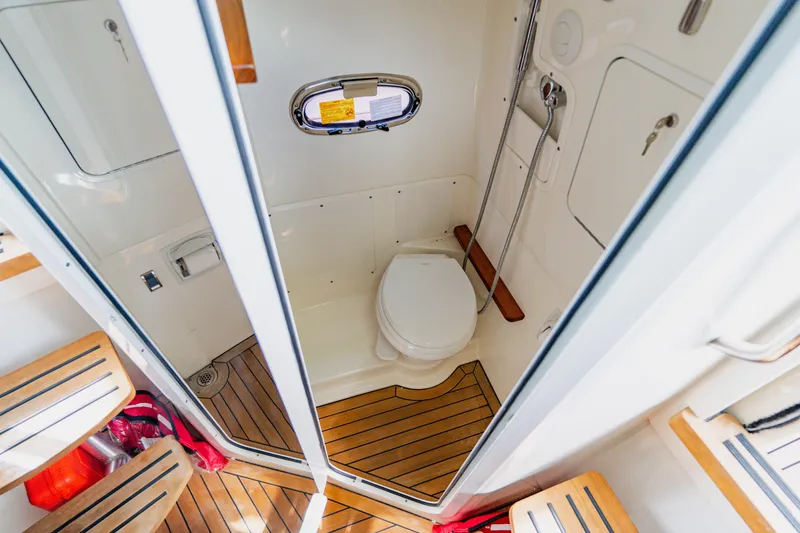 Slide: The Image of 2019 Boston Whaler 380 Outrage boat bathroom with wooden flooring and compact design. - 45