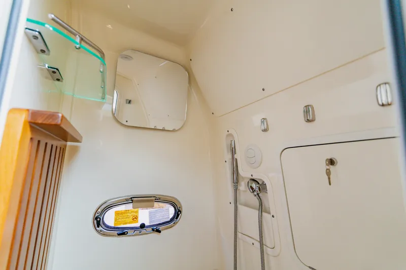 Slide: The Image of 2019 Boston Whaler 380 Outrage cabin interior with mirror, shower, and storage. - 46