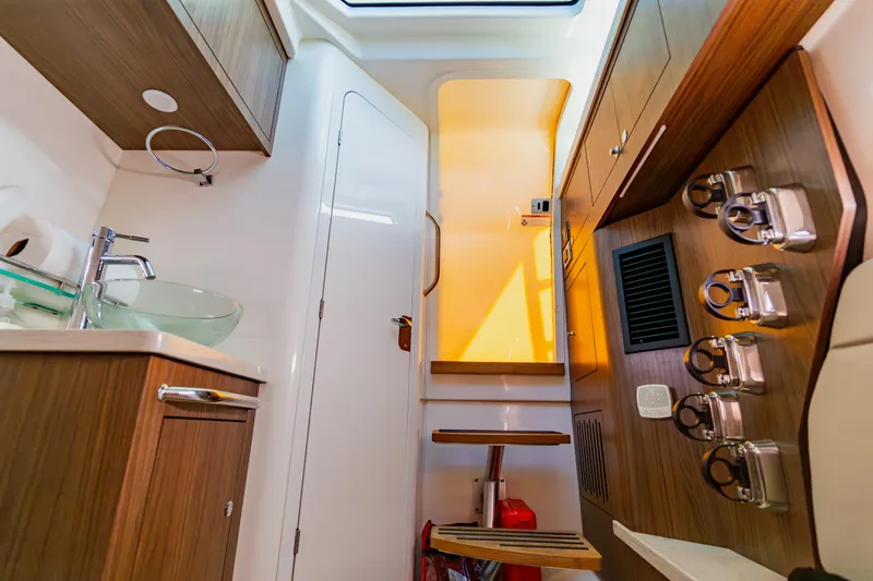 Slide: The Image of 2019 Boston Whaler 380 Outrage interior with modern wood cabinetry and glass sink. - 47