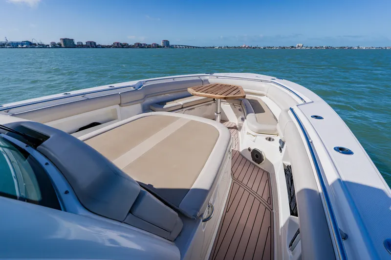 Slide: The Image of 2019 Boston Whaler 380 Outrage boat interior with seating and table on open water. - 7