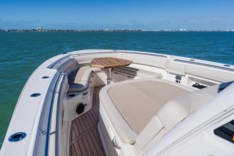 Slide: The Image of 2019 Boston Whaler 380 Outrage boat interior with seating and table on open water. - 8