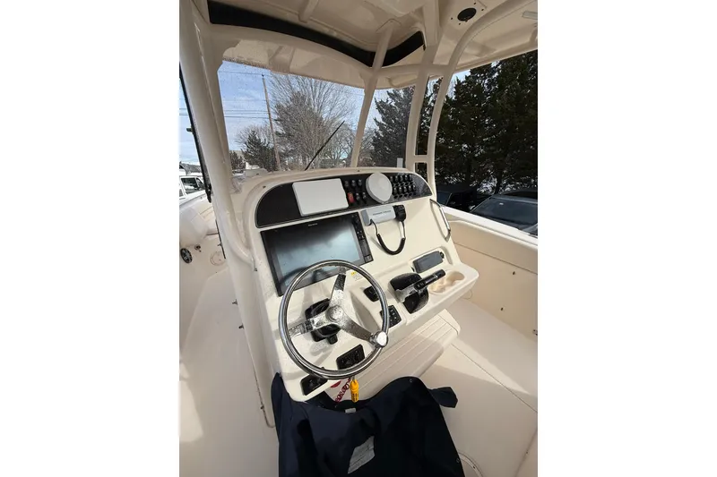 Slide: The Image of 2019 Grady-White Canyon 306 boat helm with steering wheel and navigation controls. - 11