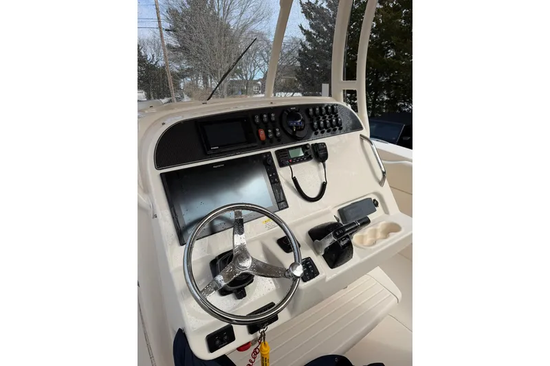 Slide: The Image of 2019 Grady-White Canyon 306 boat dashboard with steering wheel and navigation controls. - 13