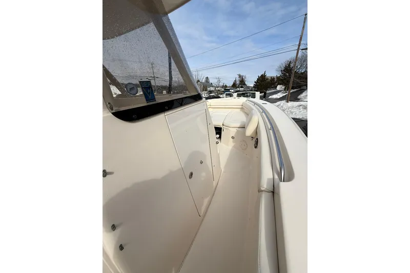Slide: The Image of 2019 Grady-White Canyon 306 boat interior with windshield and seating, under clear sky. - 16