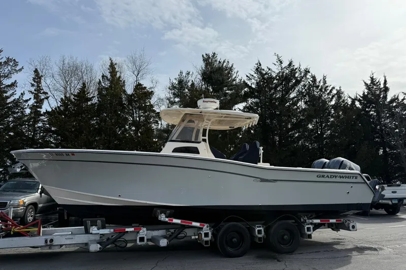Slide: The Image of 2019 Grady-White Canyon 306 boat on trailer, parked outdoors with trees in background. - 3