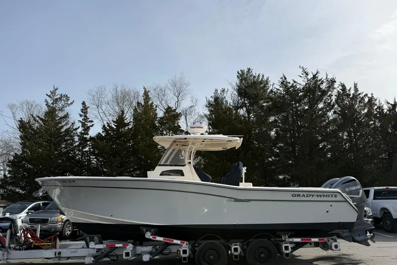 Slide: The Image of 2019 Grady-White Canyon 306 boat on trailer, parked outdoors with trees in background. - 32