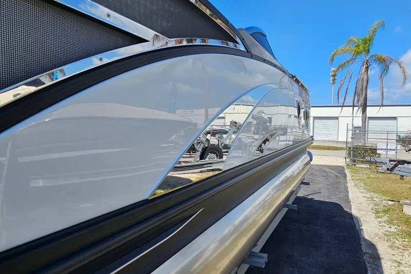 Slide: The Image of 2025 Bennington QX 27 QXSBWA X2 pontoon boat, sleek design, parked outdoors. - 5