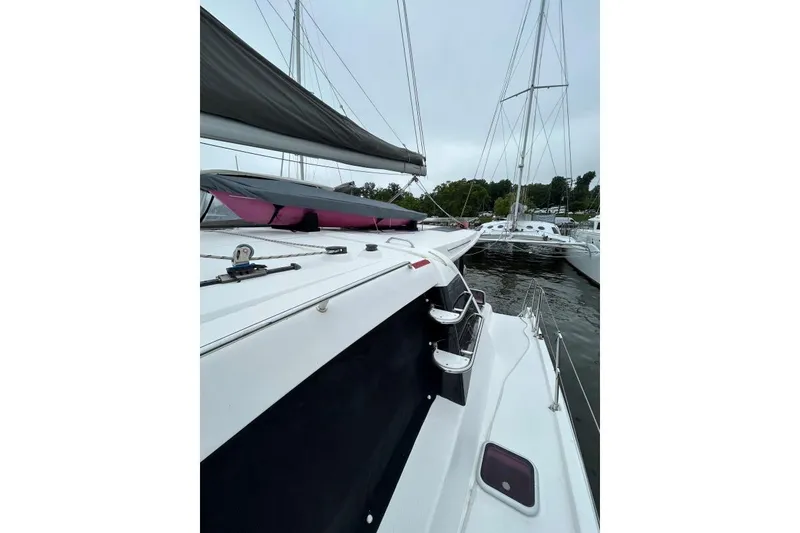 Slide: The Image of 2014 Leopard 44 catamaran docked, showcasing sleek design and spacious deck. - 24