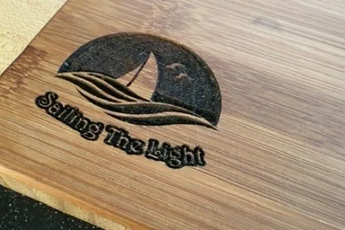 Slide: The Image of Engraved wooden plaque with sailboat logo, text "Sailing The Light," Leopard 44, 2014. - 30