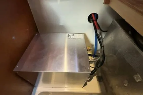 Slide: The Image of Electrical installation inside a 2014 Leopard 44 yacht, featuring wiring and metal casing. - 31